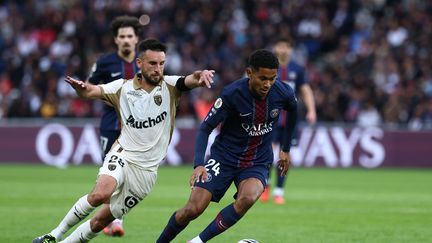 Le Parisien Senny Mayulu au duel avec le Lensois Adrien Thomasson, le 14 septembre 2025 au Parc des Princes à Paris. (FRANCK FIFE / AFP)