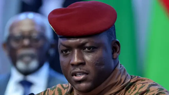 Portrait d'Ibrahim Traoré en uniforme militaire beige avec un béret rouge