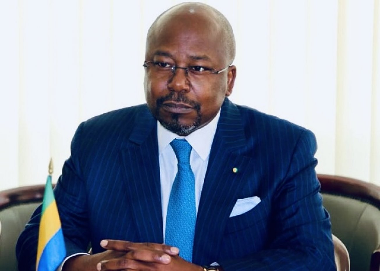 Portrait d'Alain Claude Bilie By Nze en costume sombre devant un fond neutre