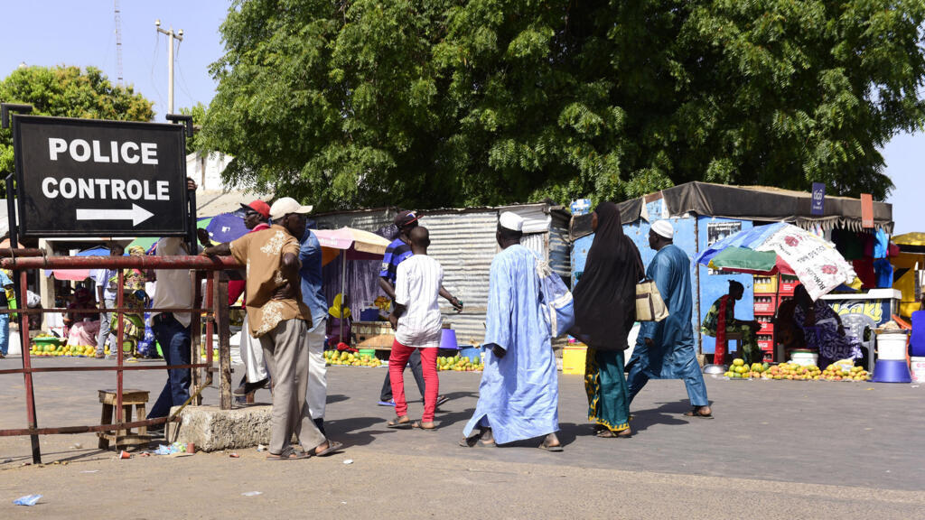 À Karang, au Sénégal, en mai 2016, des voyageurs franchissent le point de contrôle pour entrer en Gambie.
